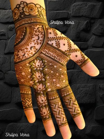 This design features delicate lotus buds on the fingers and intricate patterns on the palm, a beautiful example of detailed work.