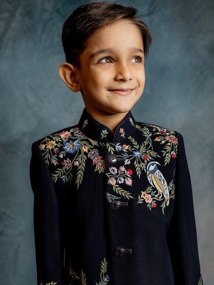 A portrait of our young model wearing the timeless embroidered Indo-western piece. His confident smile shows he feels just as good as he looks.