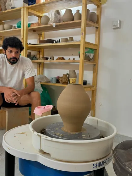Another shot of Pradyumna with his work. He enjoys exploring new techniques in both wheel throwing and hand-building, and his dedication is inspiring.