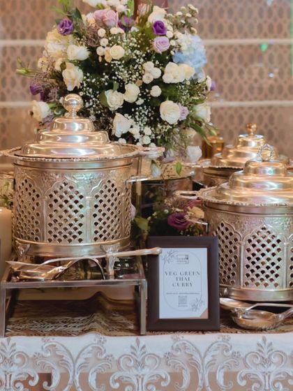 An ornate silver-plated buffet setup for a birthday celebration. The intricate design of the serveware, combined with fresh floral arrangements, creates a truly majestic and memorable dining scene.