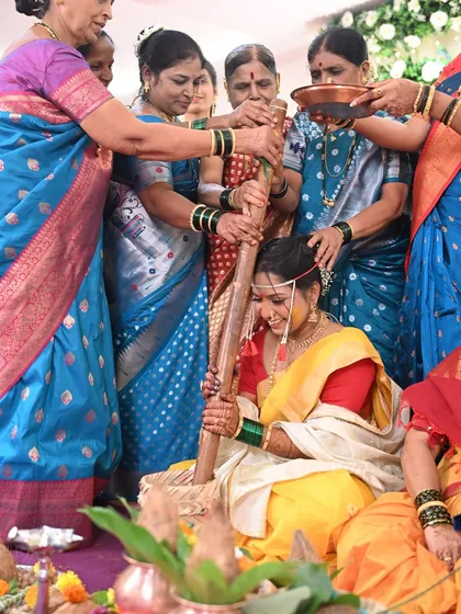Another angle from the 'Ghaana Bharne' ritual. The bride's smile and glowing makeup show that she is enjoying her special day to the fullest.