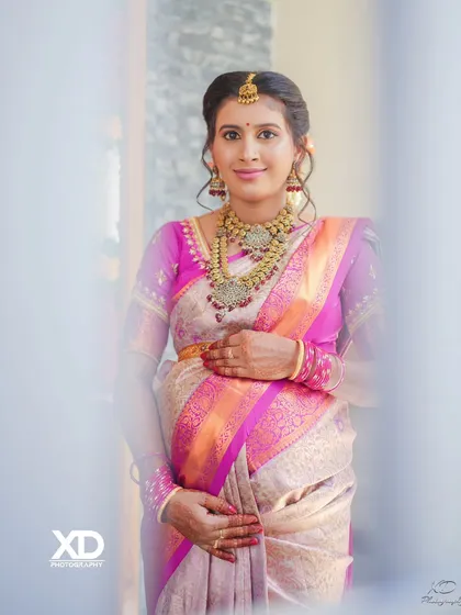 A classic, smiling portrait of the mother-to-be, framed by a doorway, capturing the happy atmosphere of her baby shower.