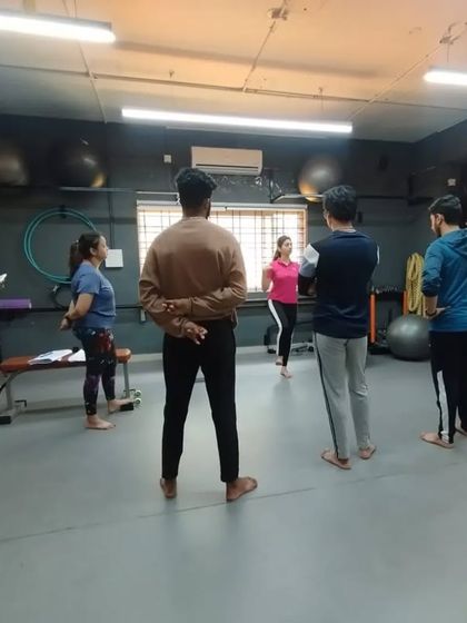 A master trainer leads a group discussion before a practical demonstration, ensuring students understand the theory behind the movements.