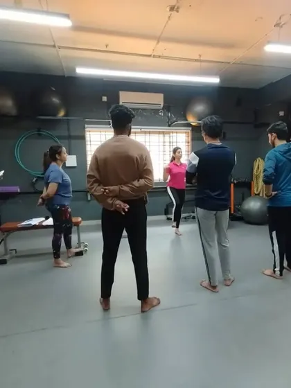 A master trainer leads a group discussion before a practical demonstration, ensuring students understand the theory behind the movements.
