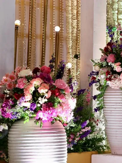 Large white vases filled with vibrant pink, purple, and white flowers, creating a bold and beautiful statement piece for any event.