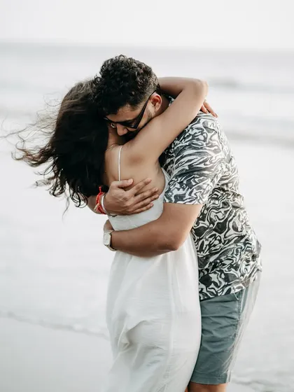 A warm, heartfelt hug with the ocean in the background. This photo captures the feeling of finding your home in each other's arms.