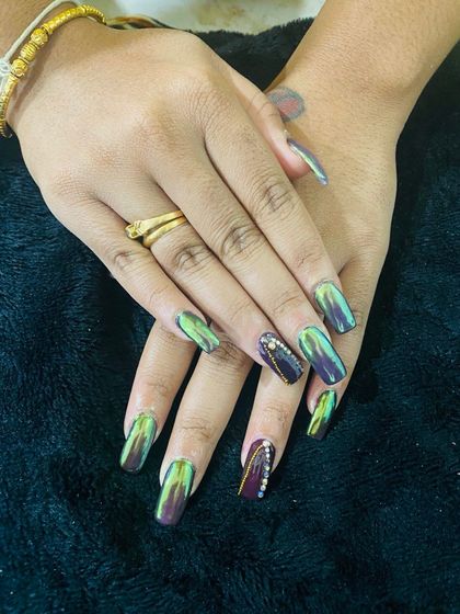 A stunning set of chameleon chrome nails. Depending on the angle and light, the color shifts between green, purple, and gold for a truly magical effect.
