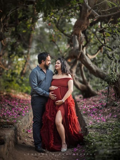A beautiful shot of the couple walking through a magical, tree-lined path, symbolizing their journey into parenthood.