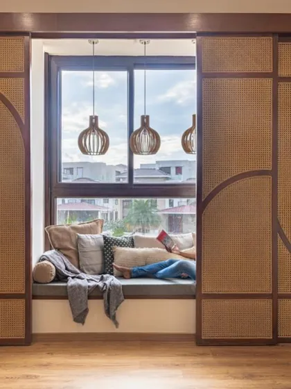 A person relaxing in a cushioned bay window nook. This image captures the essence of these spaces: they are designed for rest, comfort, and quiet enjoyment.