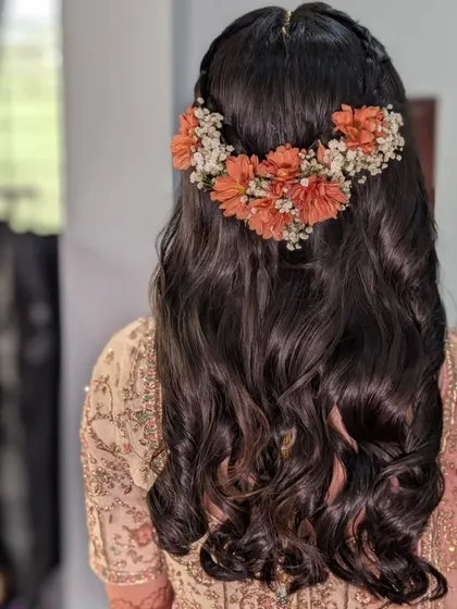 A closer look at the fresh floral hairstyle we created for Rashi's wedding day. The combination of orange and white flowers added a beautiful, natural touch to her soft curls.
