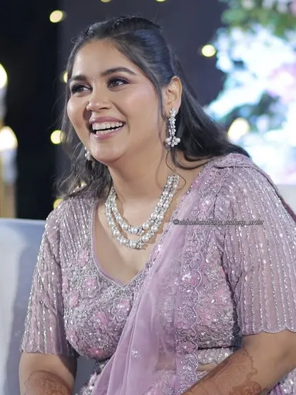 Pretty in pastels and ready for the party. This sangeet look features soft, shimmery eye makeup and a flawless base that complements her lilac lehenga and pearl jewelry perfectly.