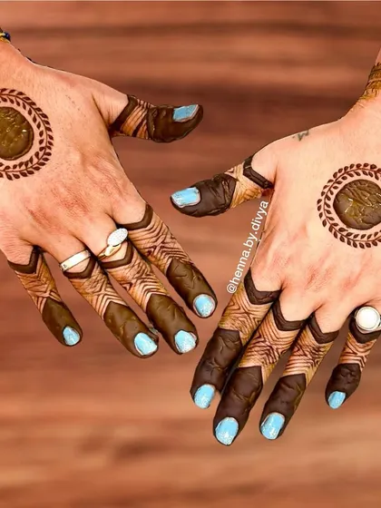 This design focuses on bold, filled-in circles on the back of the hands, framed by a leafy border. The finger designs are geometric and modern, creating a very chic and unconventional look.