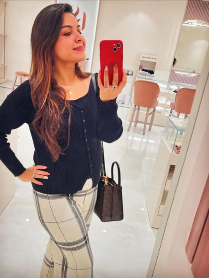 A classic office look featuring a black knit top from Lifestyle and checkered woollen trousers from GK-1 market. This shows how you can mix high-street brands with market finds for a smart, formal outfit.