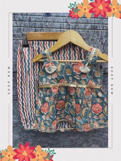 A hanging shot of our floral and striped kurta set, showing off the playful tassels and intricate border detailing.