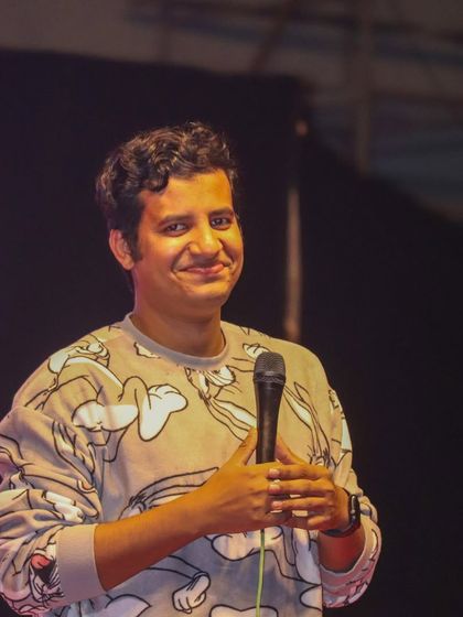 A smiling shot of Aditya Kullu, showing the enjoyable experience he provides for the audience.