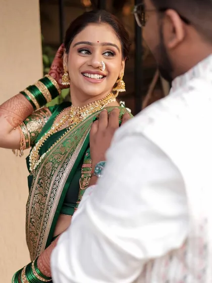 A candid moment between the bride and groom. Her soft, glowing makeup and traditional green saree create a timeless and romantic picture.