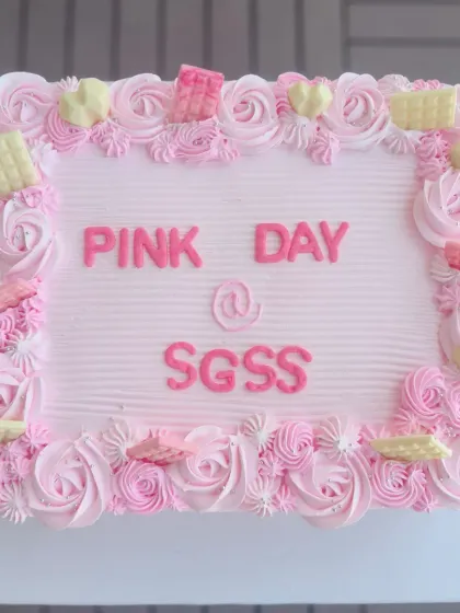 A large rectangular cake for a "Pink Day" celebration at a corporate office, with beautiful pink rosette piping.