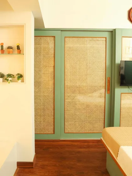 Another view of the cane wardrobe, showing how the natural texture warms up the green frame.