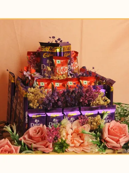 A chocolate lover's dream! This hamper is a multi-layered cake of Cadbury Dairy Milk and KitKat bars, decorated with artificial flowers. It's a fun and indulgent gift for any celebration.