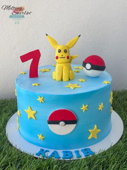 Gotta catch 'em all! This Pokémon cake features a handmade fondant Pikachu and Poké Ball. The bright blue whipped cream cake is decorated with stars, making it a fantastic choice for a young Pokémon trainer.