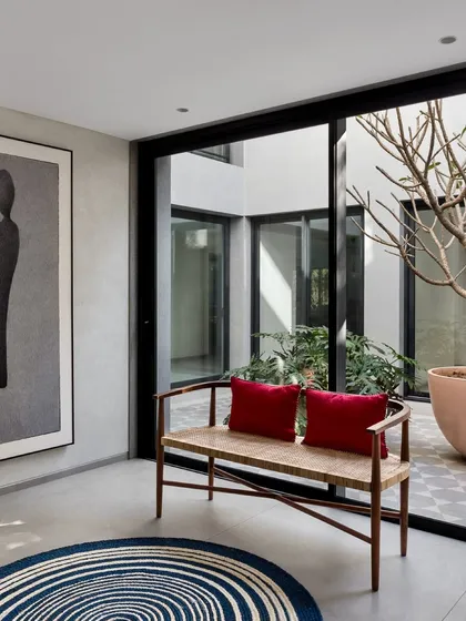 This seating nook is positioned to overlook a central courtyard, creating a peaceful indoor spot that feels connected to the outdoors. The large artwork and simple bench enhance the minimalist, gallery-like feel of the space.