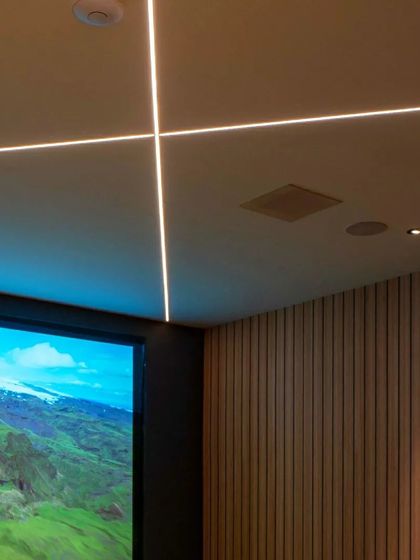 Every detail matters in a custom home theater. This series of shots highlights the clean lines of the ceiling lighting, the texture of the wood-paneled acoustic walls, and the high-quality finish of the leather recliner seats, all contributing to a premium experience.