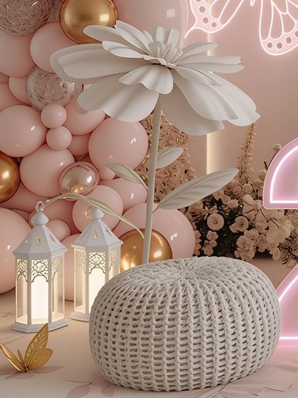 This image highlights the use of large-scale props, like the oversized white paper flower, to add a whimsical and artistic touch. Paired with soft lighting and a comfortable pouf, it creates a unique and memorable photo opportunity.