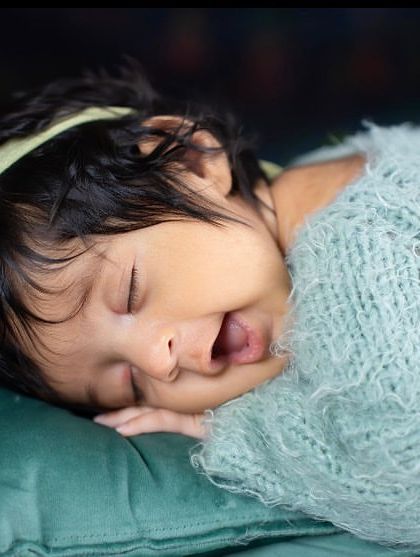 A sleepy yawn from this little one, cozy in a soft blue knit outfit. These are the authentic, unposed moments that truly capture the essence of a newborn.