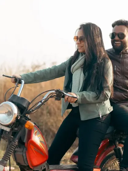 A fun, role-reversal moment with her taking the driver's seat of the moped. Their smiles show the playful, joyful dynamic of their relationship.