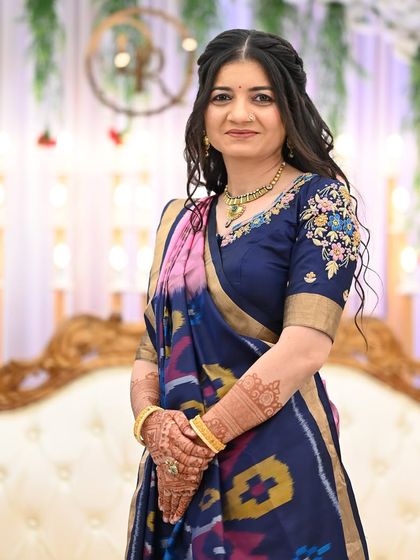 An elegant guest at a wedding, her simple yet beautifully stained mehendi peeking through.