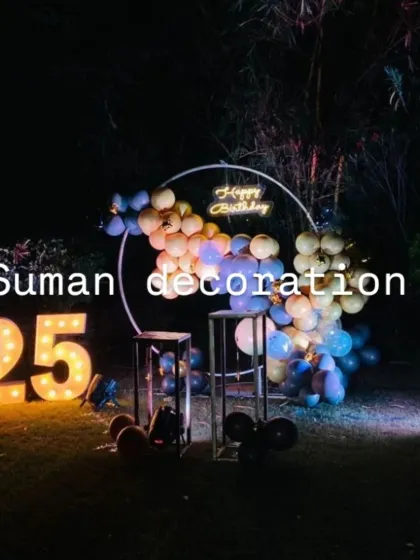 A simple and stylish outdoor birthday setup for a 25th birthday. The balloon ring and large light-up numbers create a beautiful focal point against the dark night sky.