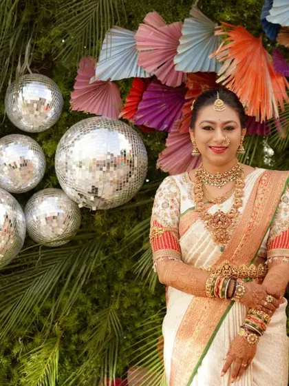 A festive wedding look. The bride's custom blouse with traditional embroidery pairs perfectly with her elegant saree, set against a vibrant and modern backdrop.