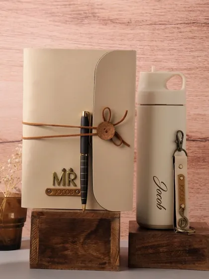 An elegant and rustic gift set featuring a personalized journal with a leather tie and a matching insulated water bottle, perfect for the man who appreciates classic style.