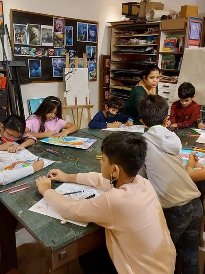 My Saturday class is a space for serious art and fun. Here, I'm providing guidance as students work on their detailed and colorful multi-medium compositions.