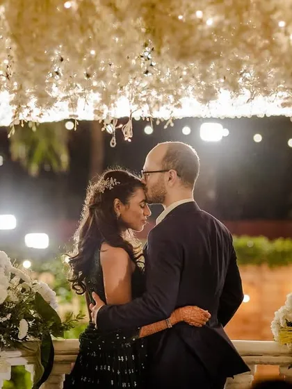 A romantic portrait with the floral decor in the foreground and the warm lights creating a beautiful ambiance.