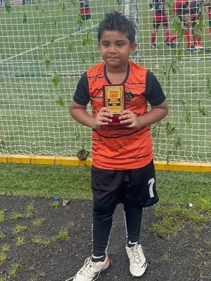 A young player proudly holding his individual award from the Mumbai 7s Championship Cup.