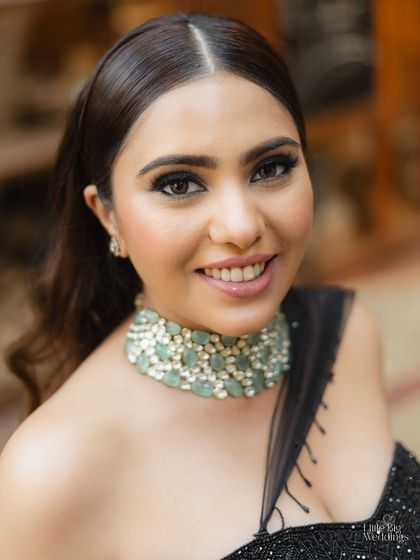 A close-up portrait of the bride, showcasing her beautiful makeup and jewelry for the cocktail night. Her smile says it all.