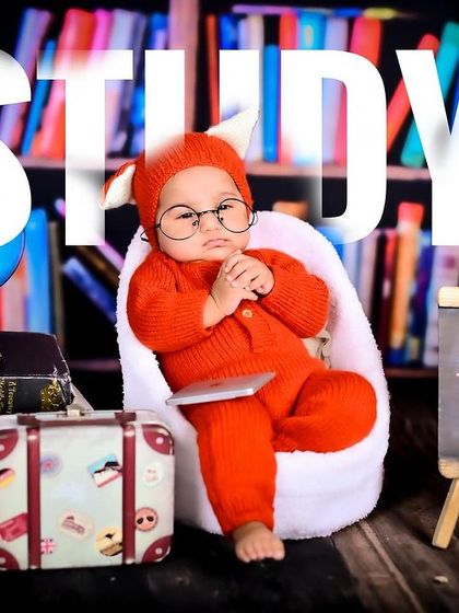 A newborn scholar in a library, complete with glasses and a tiny laptop.