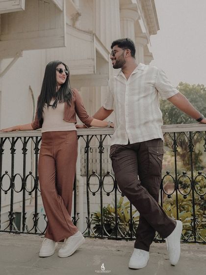 A relaxed moment, leaning against a balcony railing. This pose is perfect for capturing a candid, conversational feel.