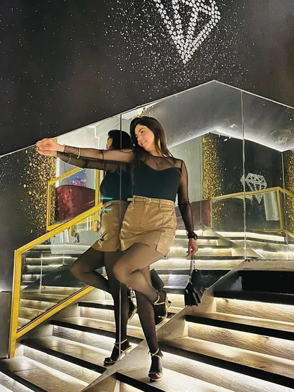 Another pose on the mirrored staircase, showing a different, more playful angle.