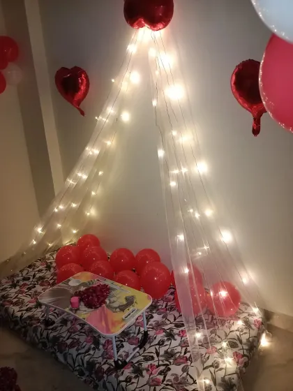 This angle highlights the heart-shaped foil balloons floating above the cabana setup. The combination of different balloon types adds texture and visual interest to the anniversary decoration.