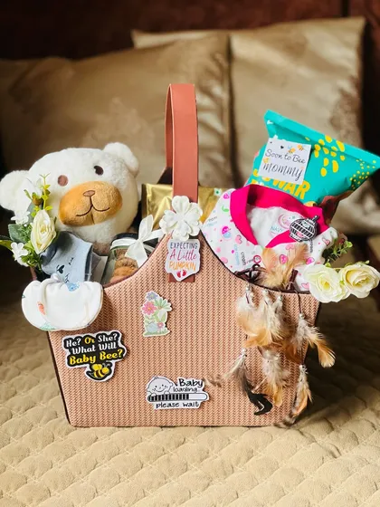 This classic mom-to-be hamper is designed to pamper. It features a soft teddy bear, baby clothes, and snacks for the expectant mother, all presented in a stylish basket with custom stickers like "Baby Loading" to add a personal touch.