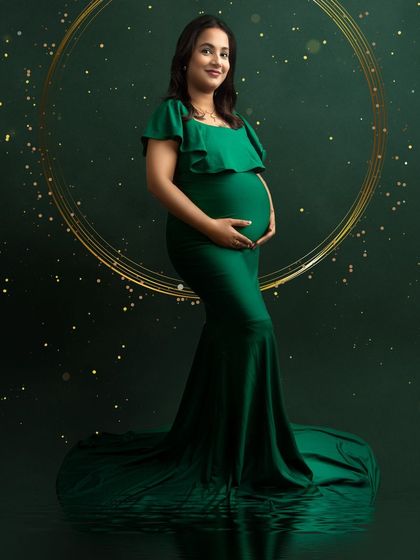 An elegant portrait in a dark green gown with a sparkling, digitally created background. The golden ring of light adds a magical touch.