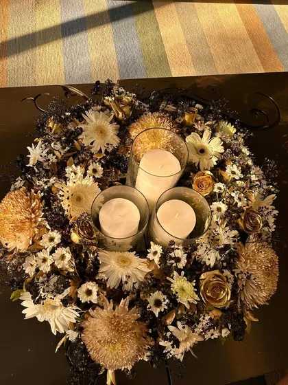 An overhead shot of the floral and candle centerpiece, showing the rich textures and colors of the flowers.