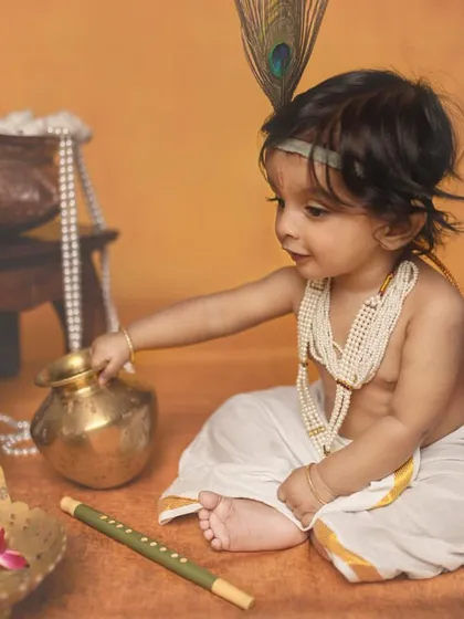 Exploring his surroundings, this baby reaches for a small brass pot. These unscripted moments are perfect for capturing a child's natural curiosity.
