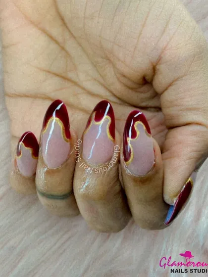 Dripping with glamour. This unique design features a nude base with a deep red "drip" effect from the cuticle, outlined in a fine gold line for a look that is both artistic and luxurious.