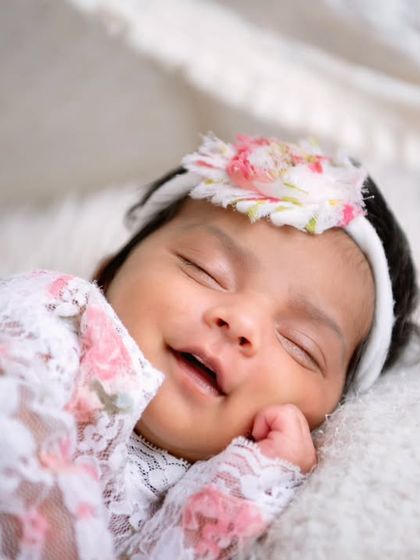 A beautiful, happy smile from a newborn in a lace outfit. These are the priceless moments I aim to capture.