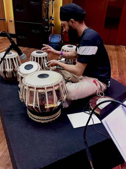 Checking the microphone placement during soundcheck. This ensures the audience hears the true, balanced sound of both the dayan and bayan drums.