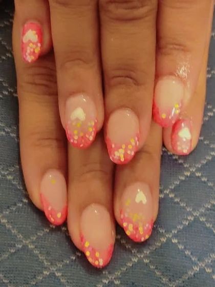 A closer look at the pink French manicure with tiny hearts and yellow and pink glitter. This is a great example of a themed party nail design.