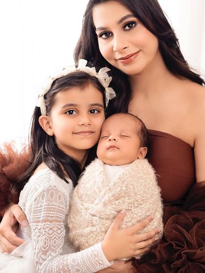 A mother, her firstborn, and her newborn, all together. This portrait beautifully captures the love that expands with each new child.